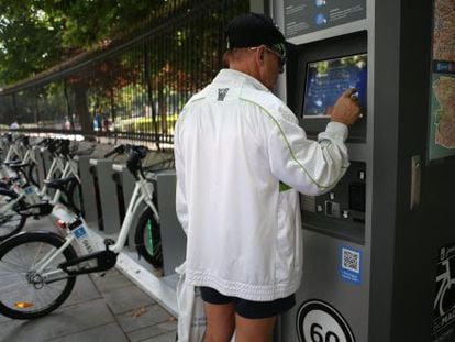 A tourist uses a BiciMad stand by the Retiro Park.