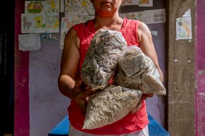 A woman carries several bags filled with coca paste in Tibú, Colombia.