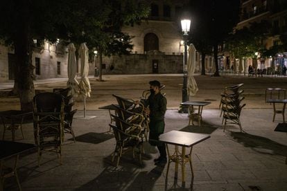A worker shuts up Malaje bar in Madrid‘s Plaza de la Paja square, just before 11pm, the new closing time under the restrictions.