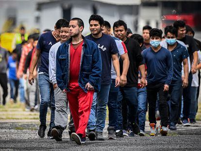 Guatemalan migrants deported from the United States walk on the airport runway upon their arrival at the Air Force Base in Guatemala City on June 21, 2023.