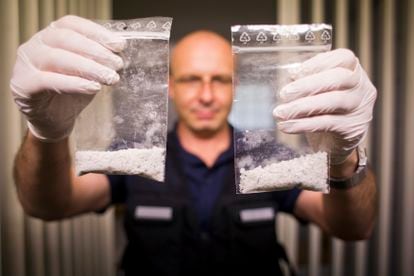 A police officer in Bavaria, Germany, displays two confiscated bags of methamphetamine; May 2014.