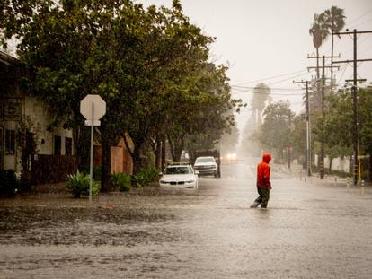 A man crosses a flooded street during an atmospheric river weather event in Santa Barbara, California USA, 04 February 2024.