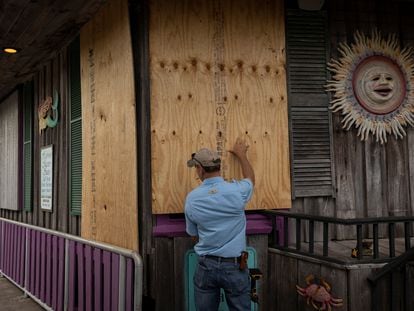 A man places plywood in front of a store ahead of the arrival of Hurricane Idalia in Cedar Key, Florida, U.S., on August 29, 2023.