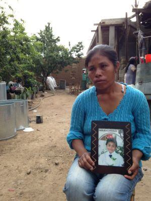 Elia Tamayo holding a photo of her son, José Luis, who died in the skirmishes on July 9. 