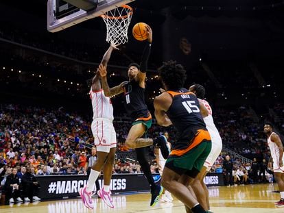Miami Hurricanes guard Jordan Miller (11) attempts a shot as Houston Cougars forward Jarace Walker, left, defends during the first half of an NCAA tournament Midwest Regional semifinal at T-Mobile Center.