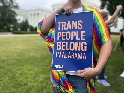 A person holds up a sign reading, 'Trans People Belong in Alabama,' during a rally outside the Alabama Statehouse in Montgomery, Ala., on International Transgender Day of Visibility, March 31, 2023.