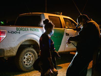 A border patrol officer processes a migrant woman after crossing the Rio Grande into Texas.
