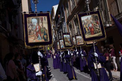 Nazarenes carrying banners with biblical passages accompany Our Father Jesús Nazareno of the Steps on Mount Calvary in Málaga on April 16, 2019.