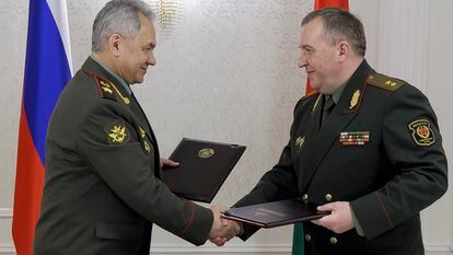 Russian Defense Minister Sergei Shoigu, left, and Belarusian Defense Minister Viktor Khrenin exchange documents during a meeting in Minsk, Belarus, on May 25, 2023.