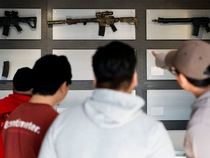 Customers look at AR-15-style rifles on a mostly empty display wall at Rainier Arms Friday, April 14, 2023, in Auburn, Wash