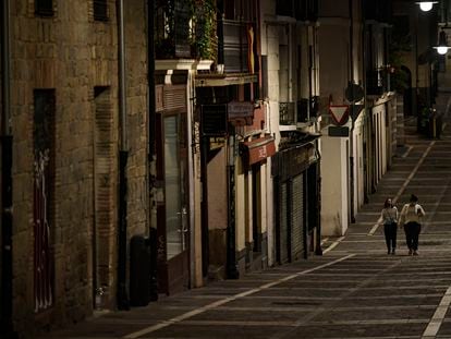 Residents wearing face mask walk along an empty street in Pamplona on October 24.