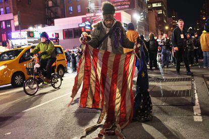 A person holds up a burned American flag during protests in New York City, on Thursday, January 26, 2023.