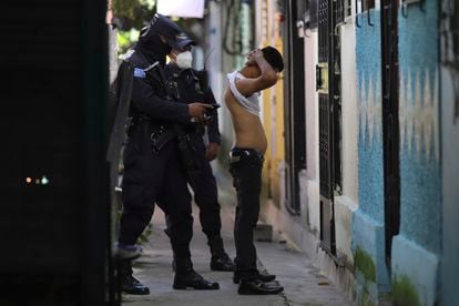 A police officer searches a man living in the Kiwanis Community, during a preventive patrol in search of gang members in Soyapango, El Salvador.