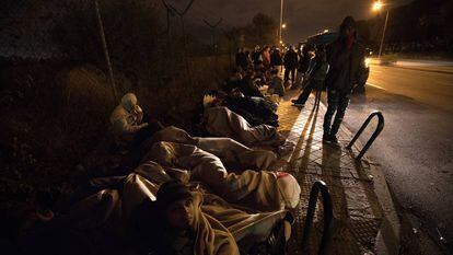Migrants sleep on the street outside the immigration office.