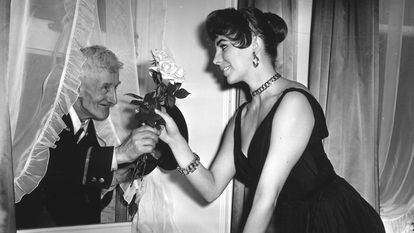 British actress Joan Collins receives flowers from an elderly admirer at her London apartment in 1955.