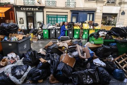 People pass by next to garbage cans overflowing with trash in Paris, France, 14 March 2023. Garbage collectors have joined the massive strikes in France against the government's pension reform plans, piling the streets of the French capital in the meantime with thousands of tonnes of garbage.
