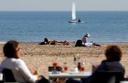 Beachgoers enjoy the unseasonably warm weather in Valencia.