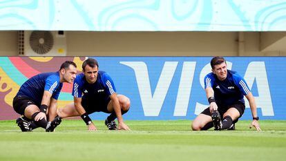 Three referees do warm-up exercises before a match at the FIFA U-17 World Cup.