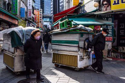 Vendors drag their street stalls along a lane in Namdaemun market in Seoul on March 13, 2023.