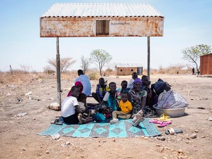 A group of South Sudanese rest in the shade of a makeshift bus stop in Renk, South Sudan, May 17, 2023.