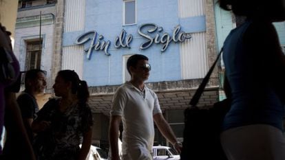 Pedestrians walk by a pre-revolutionary department store in Havana.