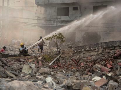 Firefighters put out a fire after a powerful explosion in San Cristobal, Dominican Republic, Monday, Aug 14, 2023