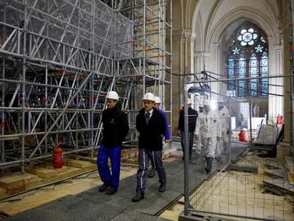 French President Emmanuel Macron (right) views the reconstruction of Notre Dame Cathedral, with the controversial stained glass windows in the background; December 8, 2023.