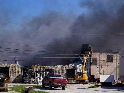 Workers knock down a section of site of an industrial fire the area as smoke billows from the site in Richmond, Indiana, on April 12, 2023.