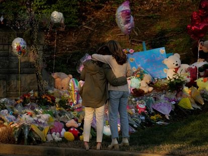 Community members embrace while visiting a memorial at the school entrance after a deadly shooting at the Covenant School in Nashville, Tennessee, on March 29, 2023.