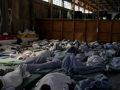 Survivors of a shipwreck sleep at a warehouse at the port in Kalamata town, about 240 kilometers (150 miles) southwest of Athens, on June 14, 2023.