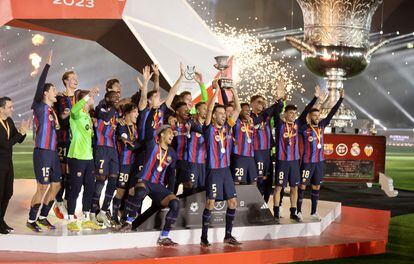 FC Barcelona's Sergio Busquets lifts the trophy as he celebrates with teammates after winning the Spanish Super Cup.