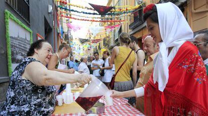 A woman serves sangría during Madrid's San Cayetano festivities.