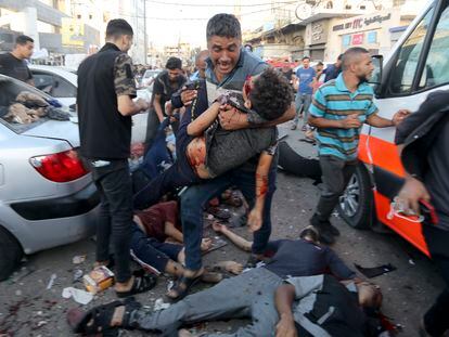 A man, with victims at his feet, carries a body after an Israeli attack on an ambulance next to the entrance of Gaza's Al Shifa hospital, Nov. 3.