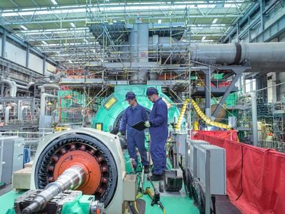 Two engineers inspect generator machinery at a nuclear power plant during an outage.