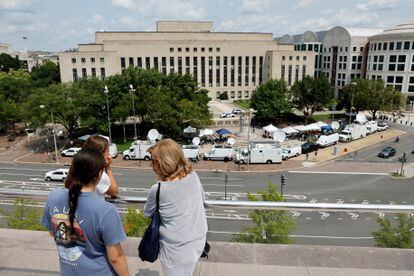 Tourists atop the National Gallery of Art look out over the news trucks in front of the federal courthouse where former U.S. President and Republican presidential candidate Donald Trump is expected to answer charges after a grand jury returned an indictment of Trump in the special counsel's investigation of efforts to overturn his 2020 election defeat In Washington, U.S. August 2, 2023.