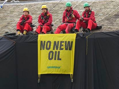 Greenpeace activists sit on the roof of Britain's Prime Minister Rishi Sunak's house in Richmond, North Yorkshire, England, after covering it in black fabric, Thursday Aug. 3, 2023.