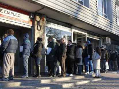 People standing in line outside a Madrid employment office.