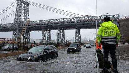 A police officer from the NYPD Highway Patrol looks as motorists drive through a flooded street after heavy rains in New York City, September 29, 2023.