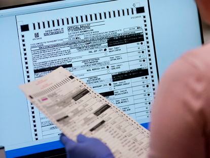 A poll worker in Maricopa County, Arizona checks a ballot on a screen.