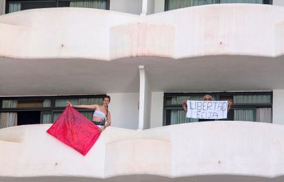 Two youngsters confined at Palma Bellver hotel in Mallorca hold signs saying “We are negative, we want to leave!” and “Freedom Écija."
