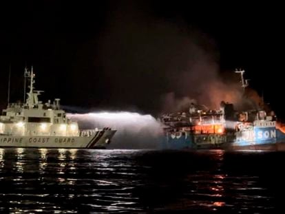 In this photo provided by the Philippine Coast Guard, a Philippine Coast Guard ship trains its hose as it tries to extinguish fire on the MV Lady Mary Joy at Basilan, southern Philippines early Thursday March 30, 2023.