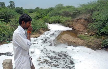 A man covers his nose at Isakavagu River, where waste from antibiotic manufacturing plants gets discharged, in a file photo from 2008.