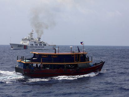 A Philippine supply boat sails near a Chinese Coast Guard ship during a resupply mission for Filipino troops in the South China Sea, October 4, 2023.