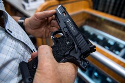 A customer checks out a hand gun that is for sale and on display at SP firearms on June 23, 2022, in Hempstead, New York.