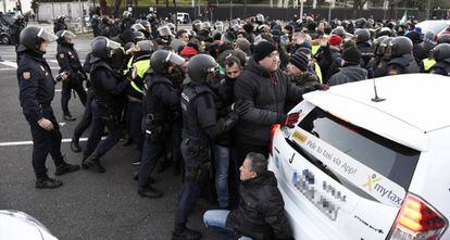 Police officers try to remove taxi drivers who have been camping out on Paseo de la Castellana since Sunday.