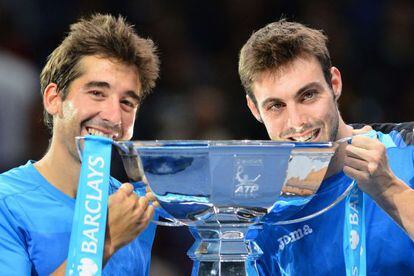 Spain&#039;s Marcel Granollers (R) and Spain&#039;s Marc Lopez (L) bite the cup as they celebrate winning the doubles final at the ATP World Tour Finals. 