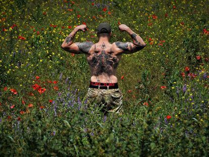 Oleksandr, a uniformed soldier fighting on the front line in Zaporizhia, shows an allegory of the war that he got tattooed on his back in February.