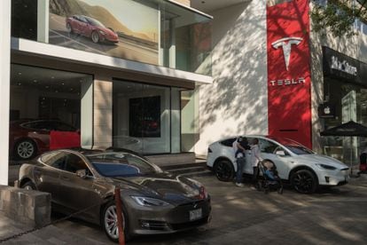 Customers look at a Tesla vehicle at a store in Mexico City.
