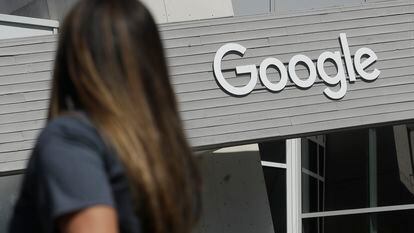 In this Sept. 24, 2019, file photo a woman walks below a Google sign on the campus in Mountain View, Calif.  Alphabet reports earnings on Tuesday, April 25, 2023