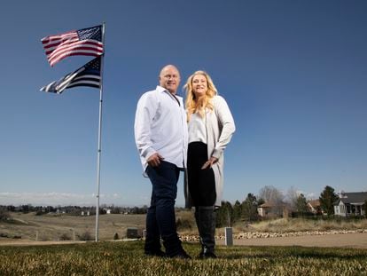 Jennifer and Tim Kohl poses for a photo in their front yard with the American flag and a thin blue line flag in Star, Idaho, on April 14, 2023.